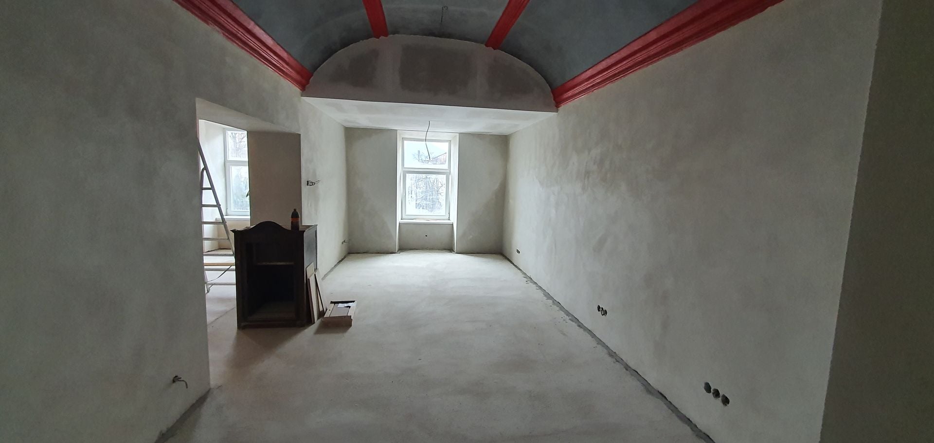Painter applying vibrant green paint on a wall, transforming the space during a home renovation project and enhancing interior decor